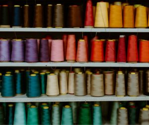 A bunch of cones of string in a variety of colours on shelves
