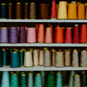 A bunch of cones of string in a variety of colours on shelves