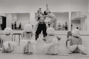 Historical dance costumes with young dancers watching two professionals all of them in elaborate costume