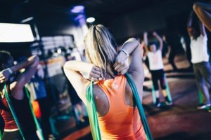 blonde woman workout class resistance band