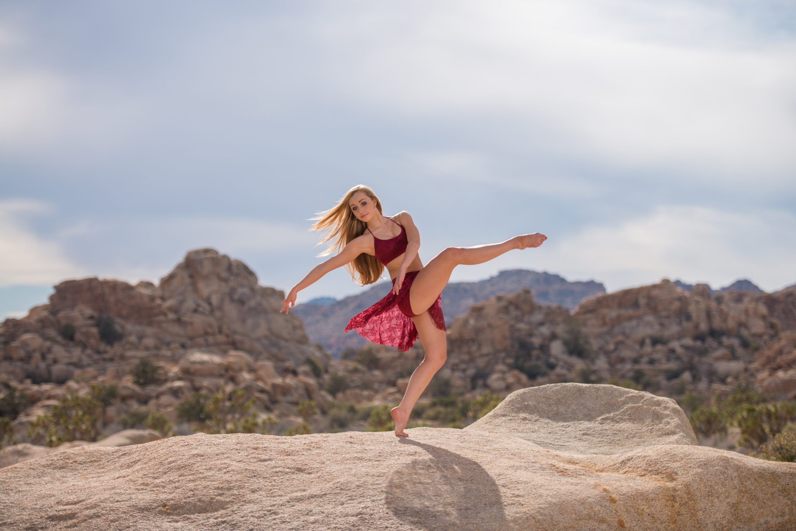 lyrical dancer wearing a red dance costume in a mountain desert